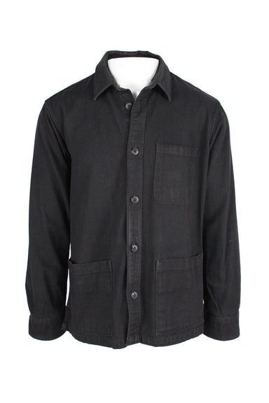 corridor black minimal chore jacket. features three pockets on front, button closure down center, small pointed collar, and long sleeves with buttoned cuffs. 