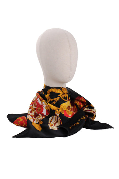  nina ricci black print scarf. features gold chains/floral print throughout, square shape, and finished edges. 