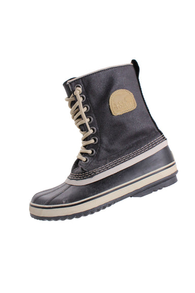 sorel weatherproof faded black and white rubber and canvas boots. features thick blue/gray felt removable lining, branding over outer ankle, rubber soles/striped toe, opposite white stitching, pull tab, and round lace closure up center. 