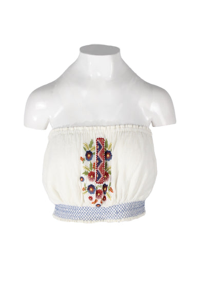 free people ivory strapless peasant style top. features multicolor floral embroidery at center front, blue smocking at hem, and crinkle-textured fabric. 