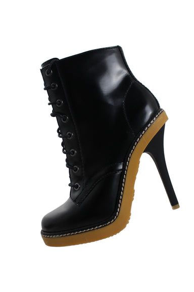 l.a.m.b. black combat boot-inspired leather ankle boots. features lace-up cord closure, gusseted tongue, contrast midsole stitching, beige textured 0.5" platform sole, and rubberized spike heel. 